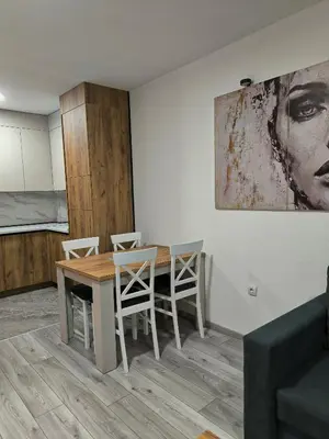 a dining room with a table and chairs and a painting at Apartman Prijedor in Prijedor