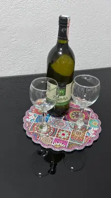 a bottle of wine and two wine glasses on a coaster at Sweet Home in Tuzla