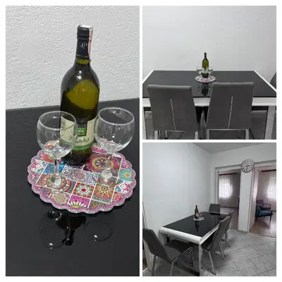 a bottle of wine sitting on a table with glasses at Sweet Home in Tuzla