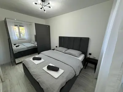 a bedroom with a large bed and a mirror at Amare Apartment in Livno