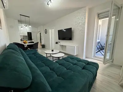 a large green couch in a living room at Amare Apartment in Livno