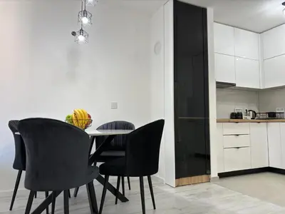 a dining room with a table and black chairs at Amare Apartment in Livno