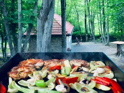 a grill with meat and vegetables cooking on it at Bungalovi Krupa in Banja Luka