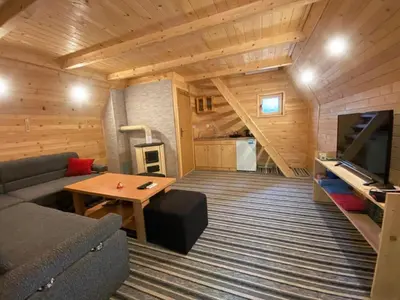 a living room with a couch and a tv and a table at Bungalovi Krupa in Banja Luka