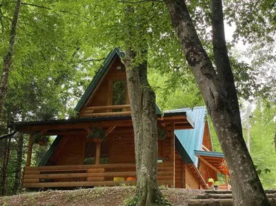 a log cabin in the woods with trees at Bungalovi Krupa in Banja Luka