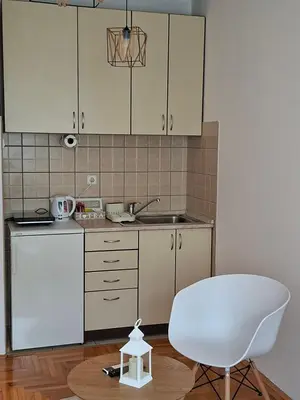 a kitchen with a white chair and a sink at Studio Maja in Banja Luka
