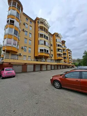 two cars parked in a parking lot in front of a building at Studio Maja in Banja Luka