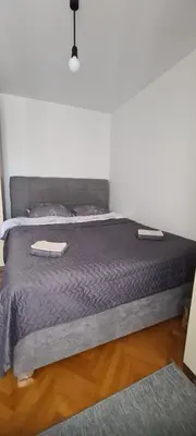 a bed with two pillows and a purple blanket at All app in Travnik