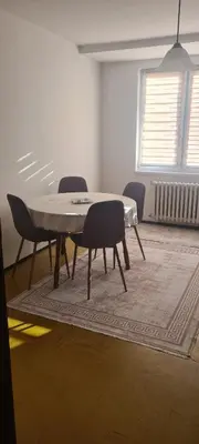 a table and chairs in a room with a rug at All app in Travnik