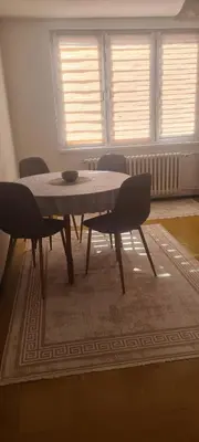a table and chairs in a room with windows at All app in Travnik