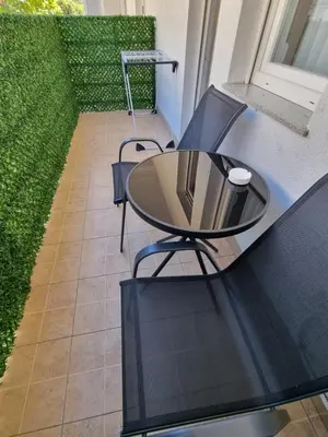 a glass table and chairs on a balcony at Apartman Nina in Banja Luka