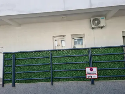 a sign on a fence in front of a building at Apartman Nina in Banja Luka