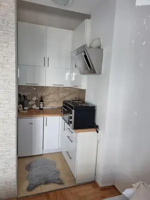 a small kitchen with white cabinets and a black microwave at Apartman Nina in Banja Luka