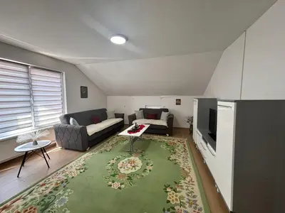 a living room with a couch and a television at Sanlej Apartman