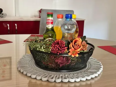 a basket of drinks and flowers on a table at Sanlej Apartman