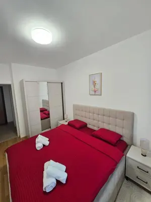 a bedroom with a red bed with two towels on it at Dana in Banja Luka