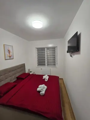 a bedroom with a red bed with towels on it at Dana in Banja Luka