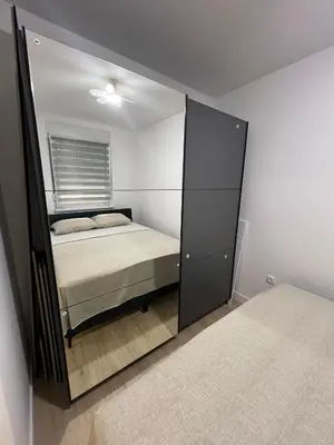 a mirror reflection of a bed in a bedroom at Lux Iva apartman in Doboj