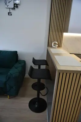 a living room with a counter and a stool at Lux Iva apartman in Doboj