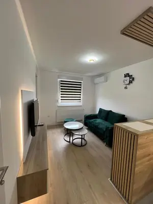 a living room with a green couch and a table at Lux Iva apartman in Doboj