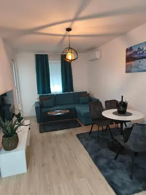 a living room with a blue couch and a table at Diva apartman, Doboj in Doboj