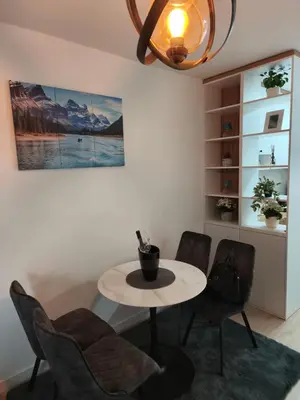 a room with a table and chairs and a painting at Diva apartman, Doboj in Doboj