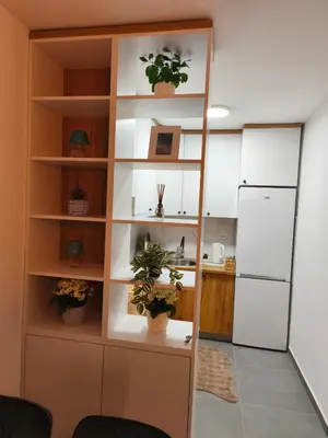 a kitchen with a shelf with potted plants and a refrigerator at Diva apartman, Doboj in Doboj