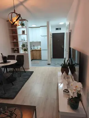 a living room with a table and a kitchen at Diva apartman, Doboj in Doboj