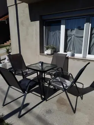 a patio table and two chairs sitting next to a window at Odmor za umorne in Banja Luka