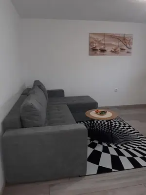 a grey couch in a living room with a table at Odmor za umorne in Banja Luka