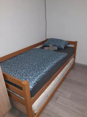 a bed with a wooden frame in a room at Odmor za umorne in Banja Luka