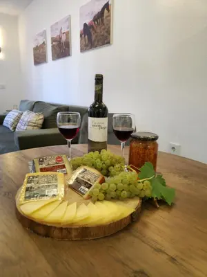 a plate of cheese and wine glasses on a table at Apartman Bistrica in Livno