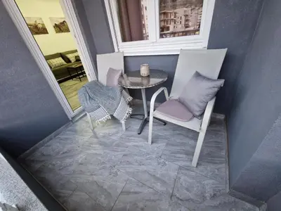 a balcony with a table and two chairs and a window at Apartman Bistrica in Livno