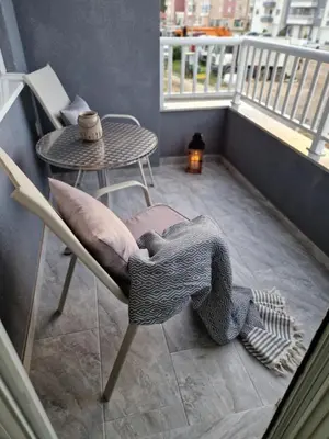 a balcony with a table and a chair with a pillow at Apartman Bistrica in Livno
