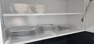a white cabinet with plates and vases in it at Apartman BINGO Bugojno in Bugojno