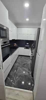 a kitchen with white cabinets and a black tile floor at Apartman BINGO Bugojno in Bugojno