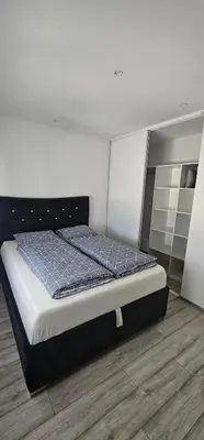 a bedroom with a bed with a blue comforter at Apartman BINGO Bugojno in Bugojno