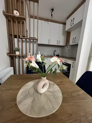 a vase with flowers on a table in a kitchen at Apartman Maja in Budžak