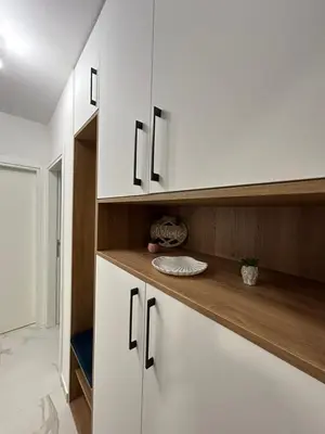 a kitchen with white cabinets and a wooden counter top at Apartman Maja in Budžak