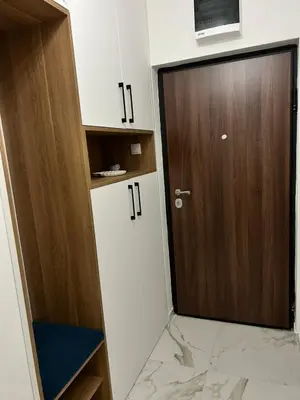 a bathroom with a wooden door and a marble floor at Apartman Maja in Budžak