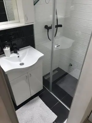 a white bathroom with a shower and a sink at Apartman Novak in Banja Luka