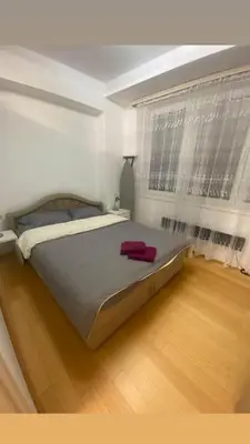 a large bed in a room with a wooden floor at Apartman Sara in Banja Luka