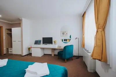 a room with a bed and a desk with a computer at Hotel Brcko Gas Doboj in Doboj