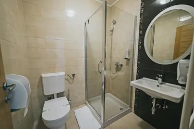 a bathroom with a toilet and a sink and a shower at Hotel Brcko Gas Doboj in Doboj