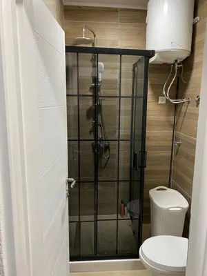 a shower stall in a bathroom with a toilet at Elyisian Home in Zenica