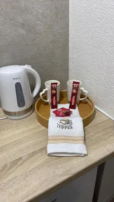 a counter with two cups and a towel and a toaster at Elyisian Home in Zenica