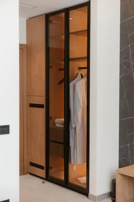 a wardrobe with glass doors in a room at Tradicija Hotel in Banja Luka
