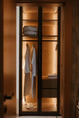 a closet with a glass door with clothes in it at Tradicija Hotel in Banja Luka