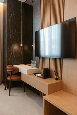 a room with a desk with a television on a wall at Tradicija Hotel in Banja Luka