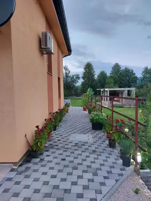 a brick walkway with potted plants next to a building at Zem Zem kuća za odmor in Otoka